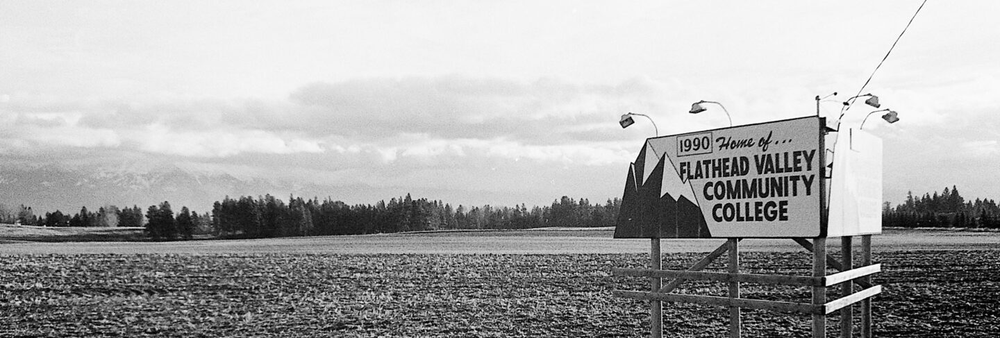 a sign in a field reads 1990 home of flathead valley community college