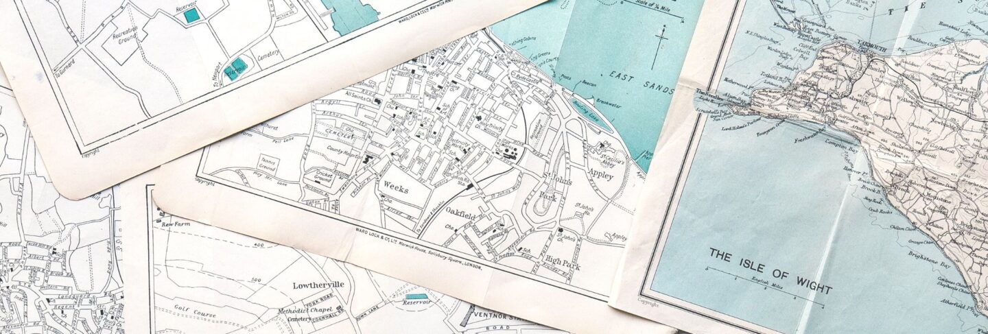 detail photograph of maps of the isle of wight spread out on a table