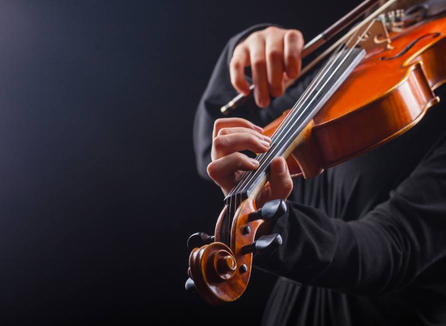 close up of musician's hands playing a violin